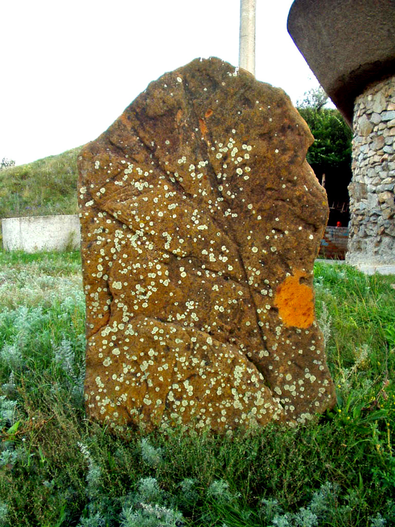 Камень со стертыми петроглифами.