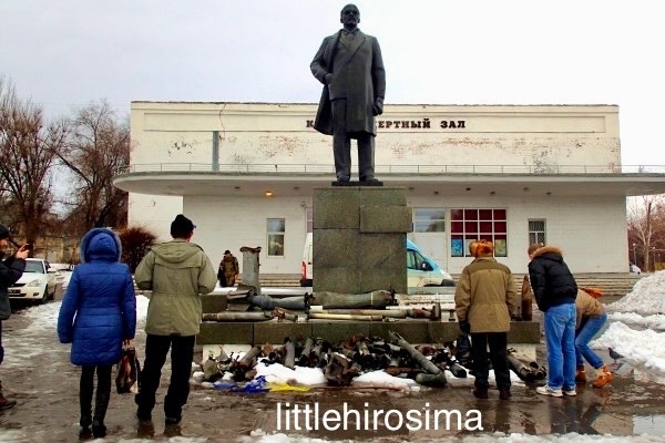 Центр города Первомайск, ЛНР. Февраль 2015 года. Растоптанный украинский флаг и снаряды, которые жители принесли под памятник.