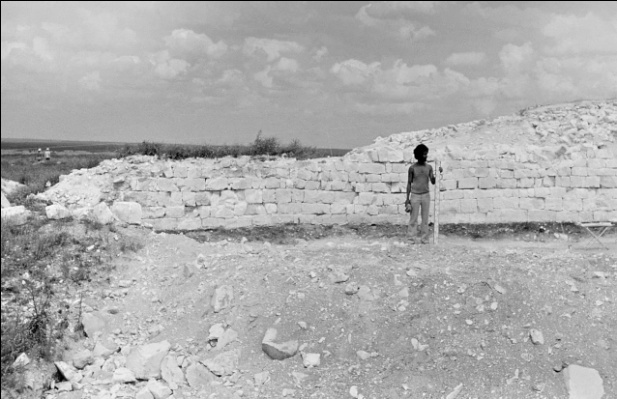 Студент практикант с рейкой на фоне Маяцкой крепости.