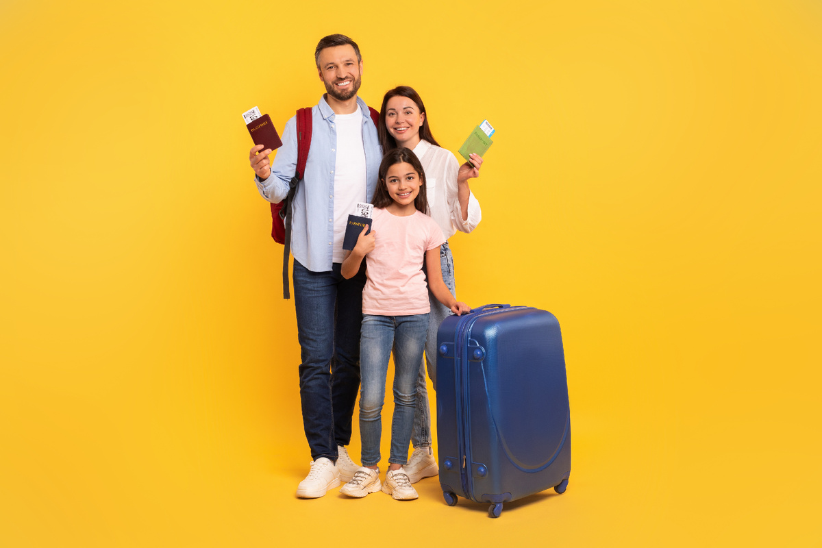 Счастливые родители с ребенком, держащие заграничные паспорта, готовящиеся к путешествию за границу в 2025 году