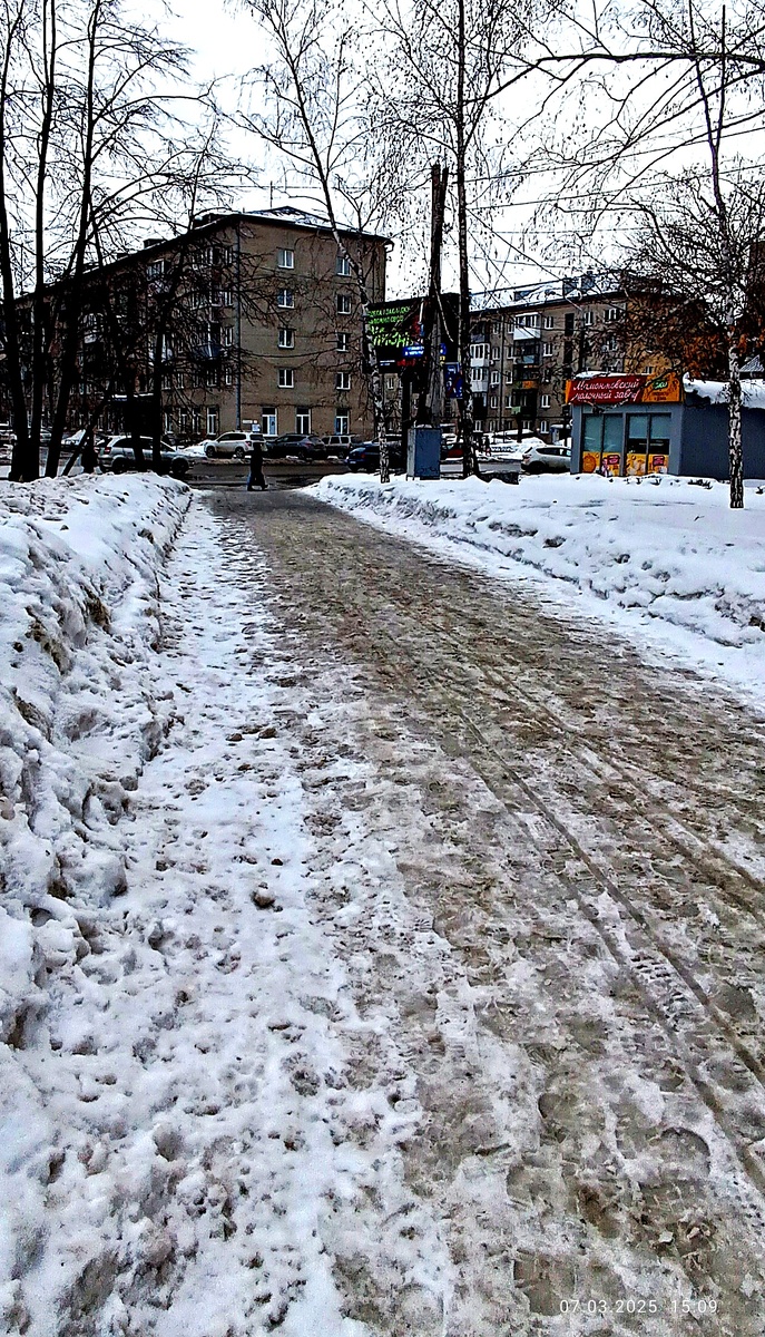 Тающий снег на тротуаре, далее, в конце тротуара, уже голый асфальт. Где-то на просторах моего города. Фотография автора, март 2025 года. 