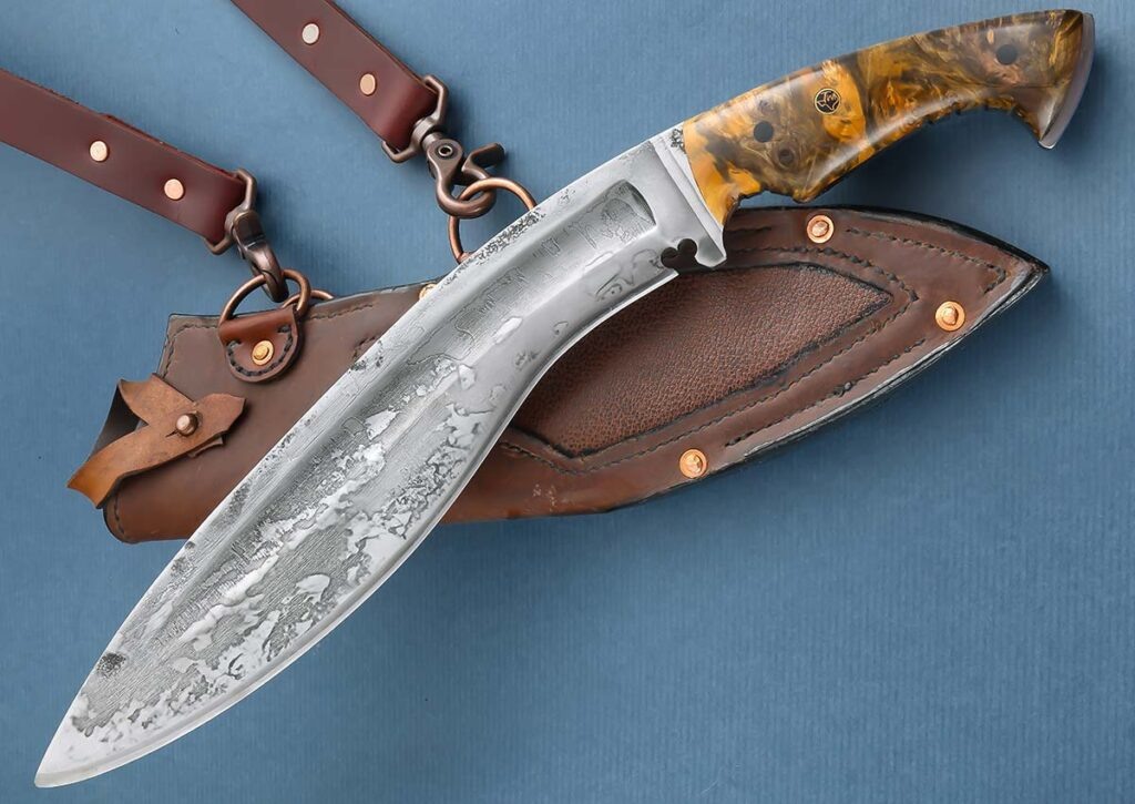 Kukri от Thomas Taylor оснащен 305 мм фуллеренным лезвием из инструментальной стали W2 со сложной фаской и испанской насечкой в форме сердца. Рукоятка: заусенец "бакай". Общая длина: 430 мм . Ножны из воловьей кожи и водяного буйвола . 
