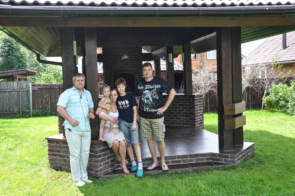 Довольные клиенты на фоне построенной беседки