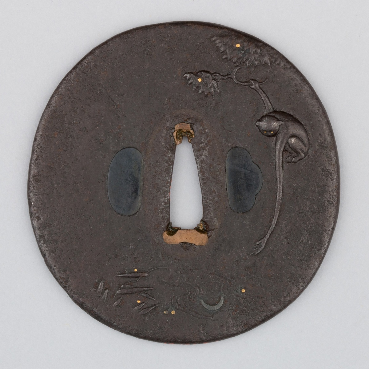 На лицевой стороне цубы китайская обезьяна держится лапкой за ветку, а другой тянется к отражению луны. Рядом поблёскивают светлячки, реющие над водой. Композиция действительно очень напоминает неудачную работу Канэиэ.