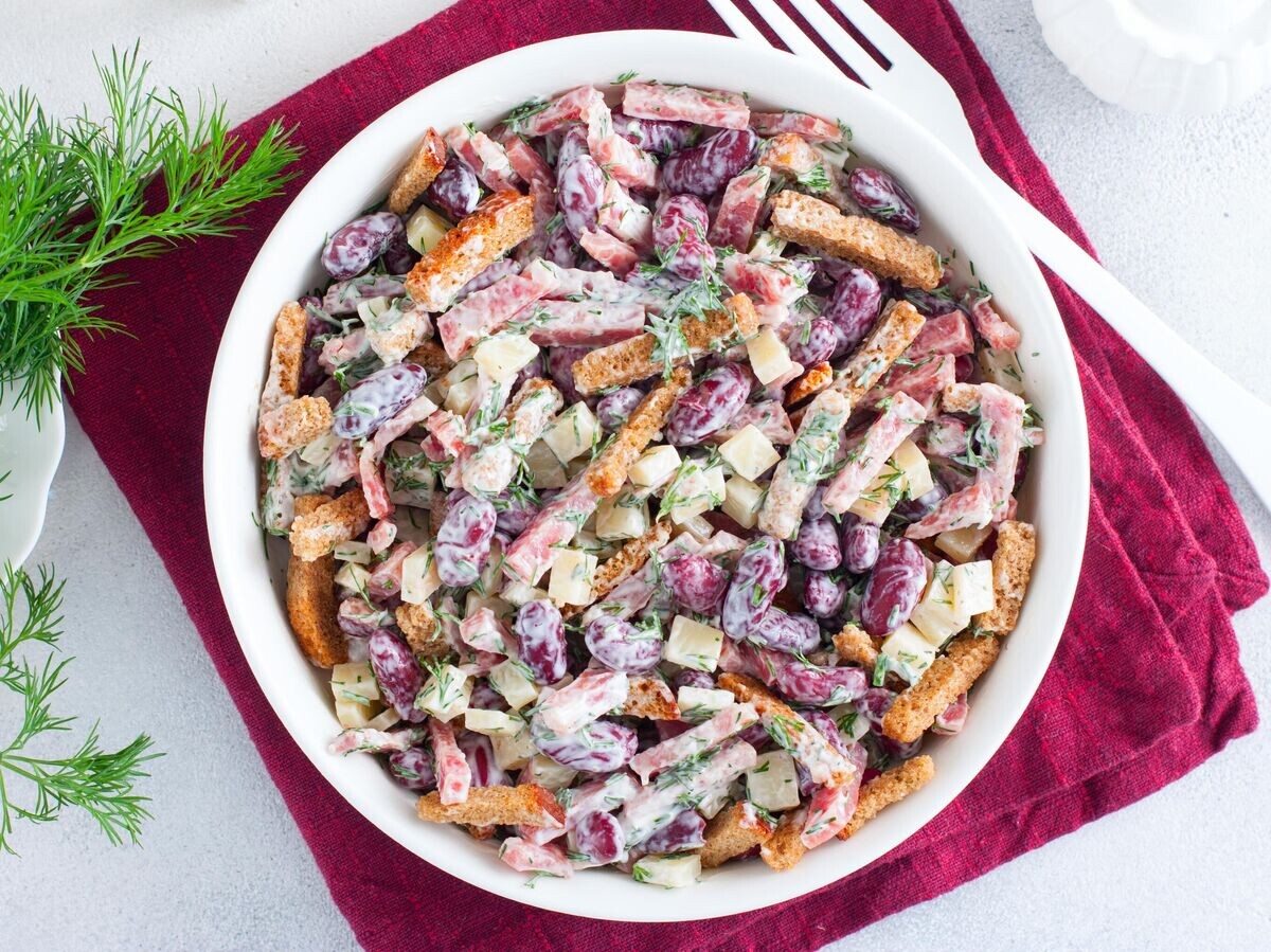    Салат с красной фасолью, колбасой, сыром и сухариками© Getty Images / Ann_Zhuravleva