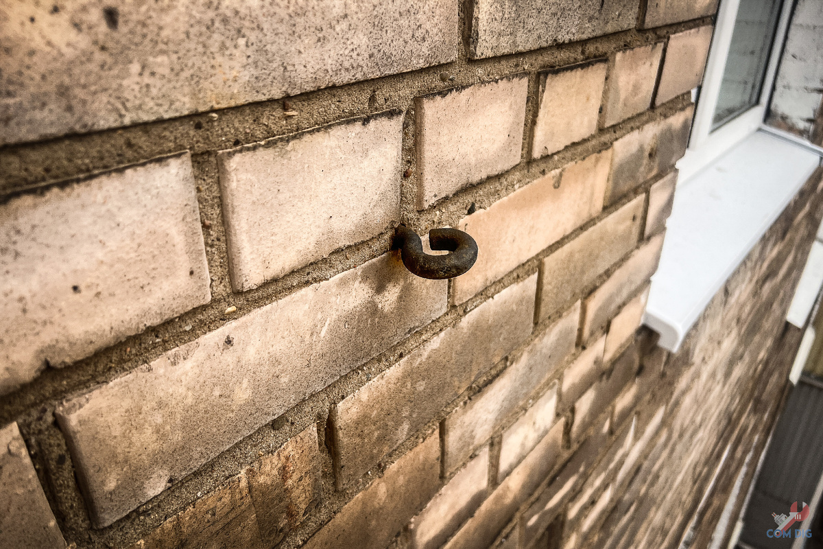 Крюк на фасаде кирпичной хрущевки.    