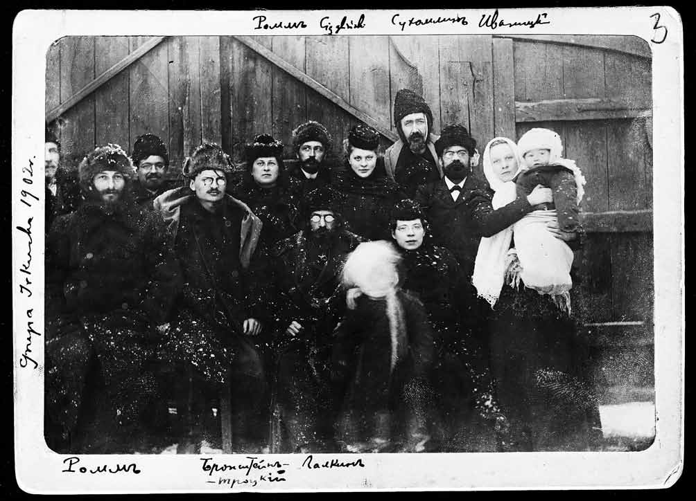 Троцкий (сидит в ряду, второй слева) и Александра Соколовская, держащая на руках свою дочь от Зину (стоит первой справа)