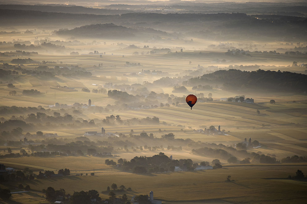 На этом снимке, сделанном в округе Ланкастер, штат Пенсильвания, на самом деле изображена земля. “Утренний туман окутывал землю, придавая ей мягкий, приглушенный вид, - говорит Майкл, - и нужно было что-то выделяющееся. Без воздушного шара это просто красивый пейзаж, а с ним - история о полёте!”. Z7 + NIKKOR 28-300 мм f/3,5-5,6G ED VR и Mount Adapter FTZ, при 1/1000 сек., f/5,6, ISO 200, ручная экспозиция, матричный замер. © Michael O'Neill 