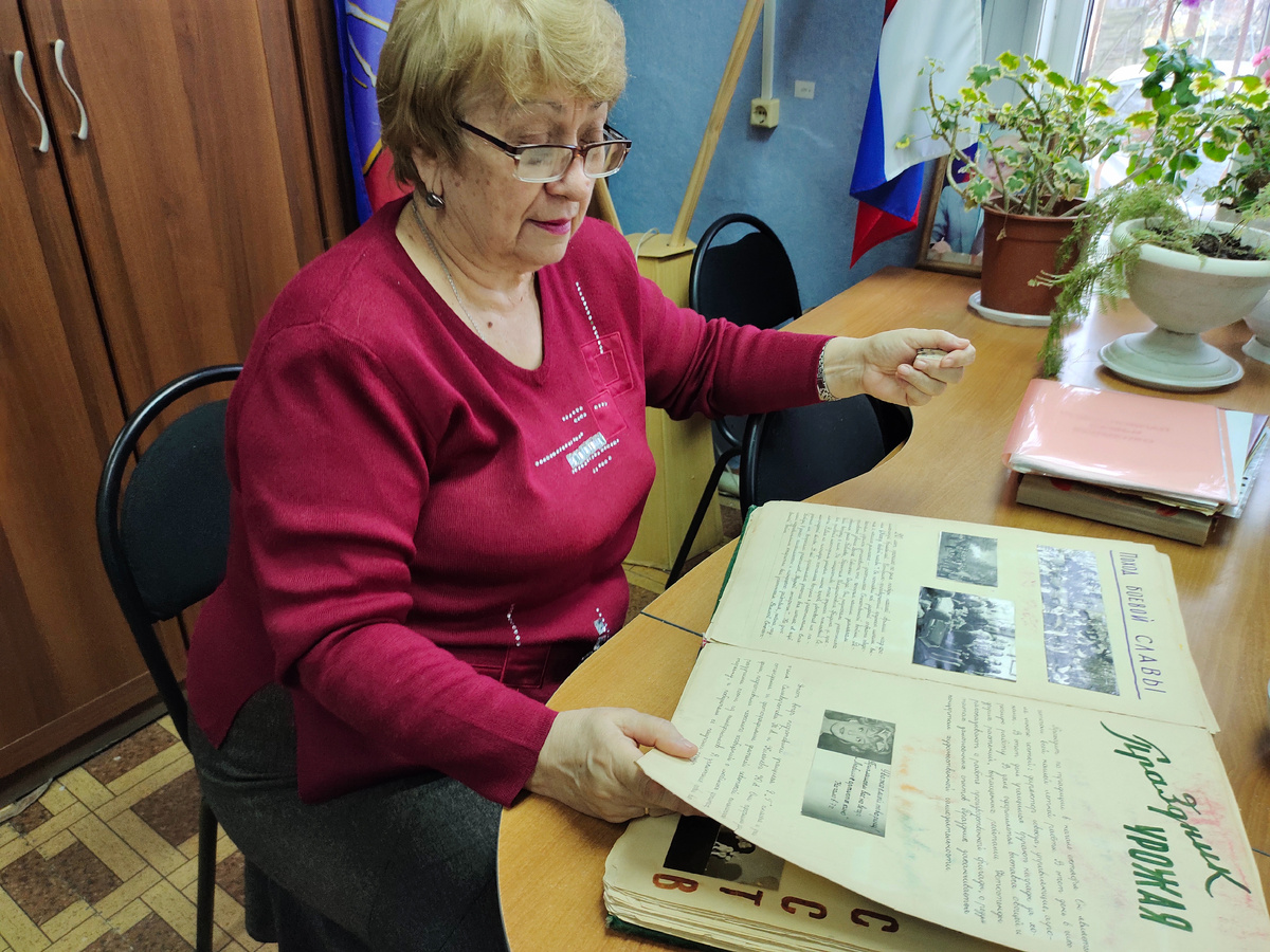 Е.Ф.Напалкова  рассказывает историю первой средней школы города Суровикино и демонстрирует  альбом с фотохроникой самых важных событий 