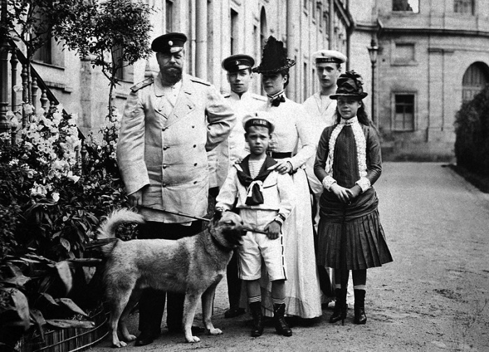 Александр  III с семьей в Гатчине, 1887 год. Слева направо: император Александр  Александрович, цесаревич Николай Александрович (будущий император  Николай II), великий князь Михаил Александрович, императрица Мария  Федоровна, великий князь Георгий Александрович, великая княгиня Ксения  Александровна. Источник: picturehistory.livejournal.com