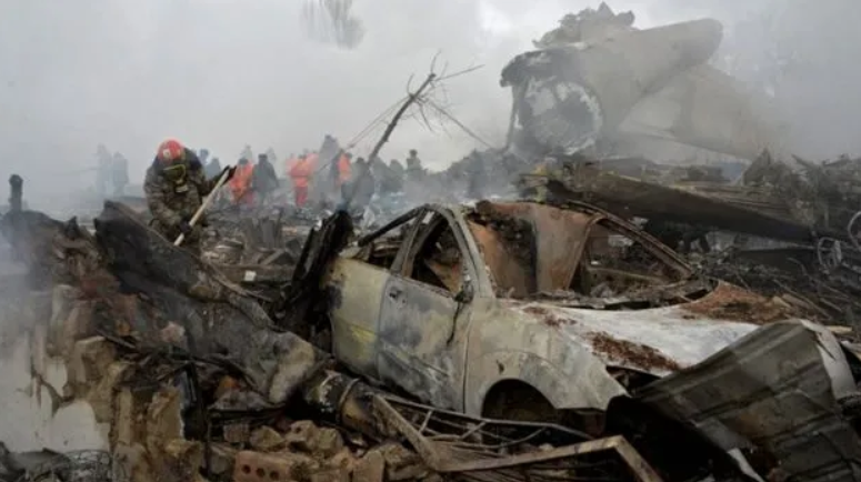 Пожарный разбирает обгоревшие обломки в киргизской деревне после крушения рейса 6491 авиакомпании Turkish Airlines. (BBC)
