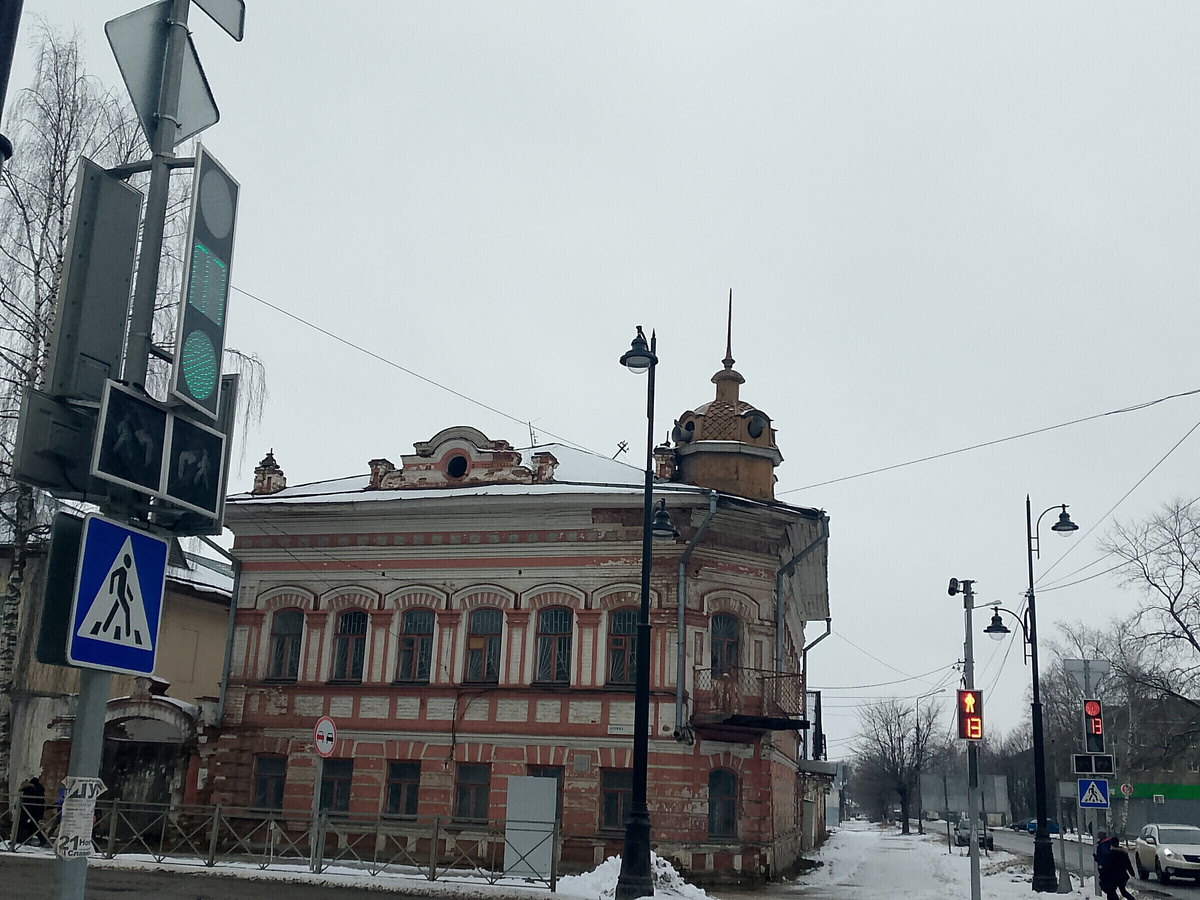 Особянк Виноградовых. Фигурный аттик с круглым окном расположен на крыше слева от купола со шпилем. Такой же есть на другом фасаде. 