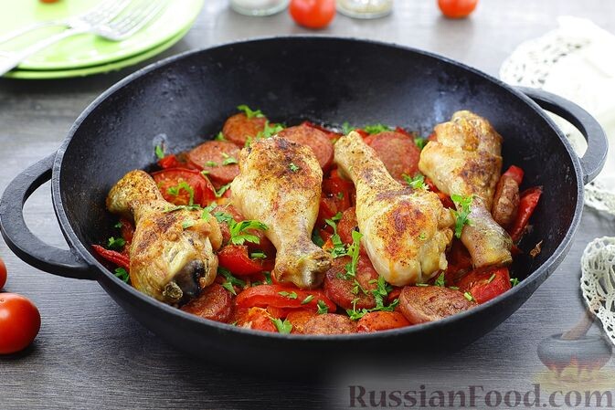 куриные голени, колбаски полукопчёные, помидоры, перец болгарский, лук репчатый, чеснок, паприка молотая, зелень петрушки, соль, перец чёрный молотый, масло растительное