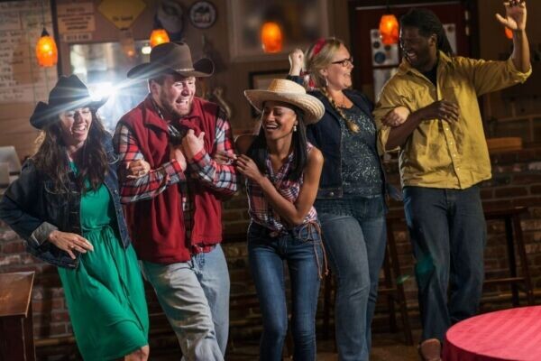 Люди в баре носят ковбойские шляпы/