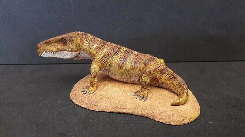 Фигурка гарджаинии сидящей на песке.