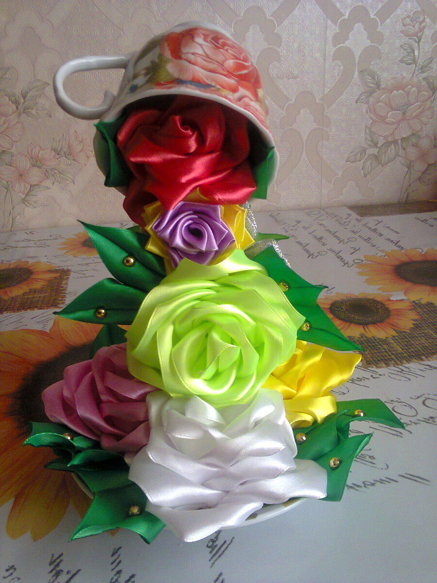 В состав входит(чашечка и блюдце, проволока, клеевой пистолет, цветы из атласной ленты или искусственные цветы, можно бусины использовать, зерна кофе и т.д.)