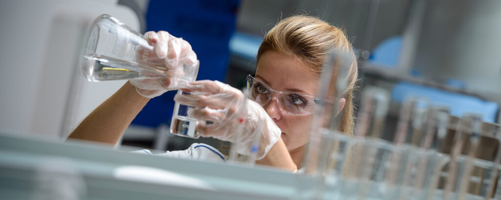    Лаборантка с мензуркой белого масла