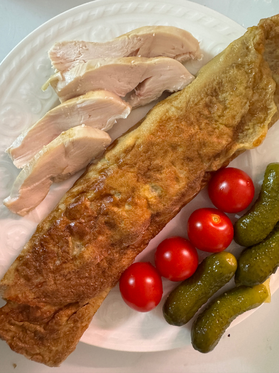 Готовый омлет с сервировкой курицей и овощами