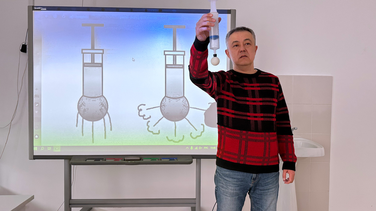 Сельский учитель во время урока физики