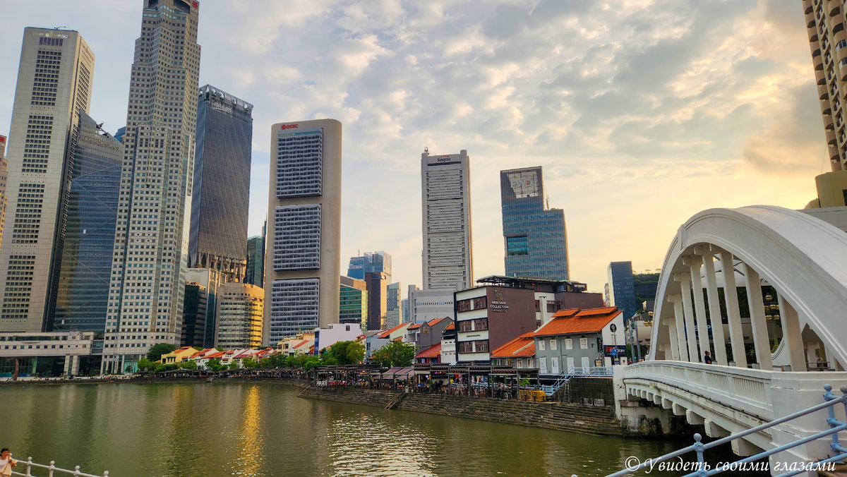 Историческая набережная Boat Quay в Сингапуре. Когда-то здесь был причал для торговых судов и склады, где хранили грузы. Сейчас в этих домишках на берегу реки расположились рестораны