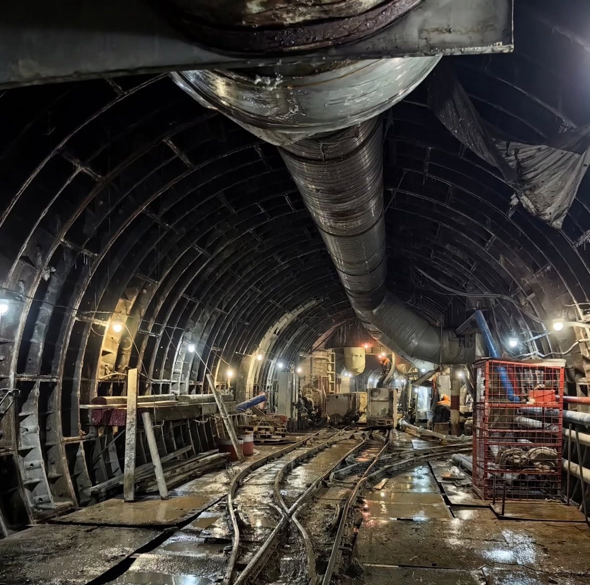 📷 1.1: Руддвор. Сюда откатывается порода для дальнейшего подъёма на поверхность по шахтному стволу. Сам ствол — впереди, направо уходит сбойка с возводимым тоннелем «на Звенигородскую». Прямо, после ствола — ходки к демонтажным камерам. За спиной — ходок к строящейся камере примыкания к бывшему тоннелю БКЛ «на Хорошёвскую».