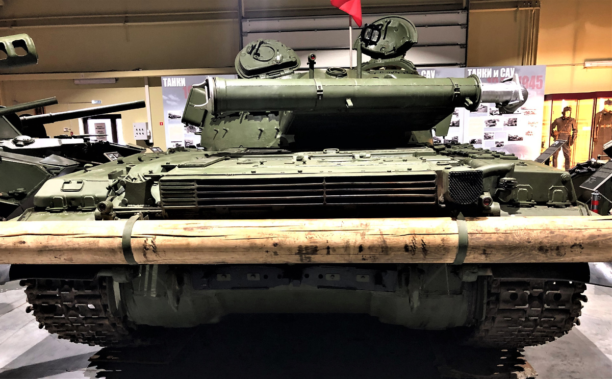 Характерные для машин выпуска второй половины 70-х укороченная решетка выходных жалюзи и клапан обводного газохода ( правее) в откидной крыше МТО кормовой части корпуса. Левее, за вертикальным ребром- жалюзи клапана выброса пыли из воздухоочистителя. 