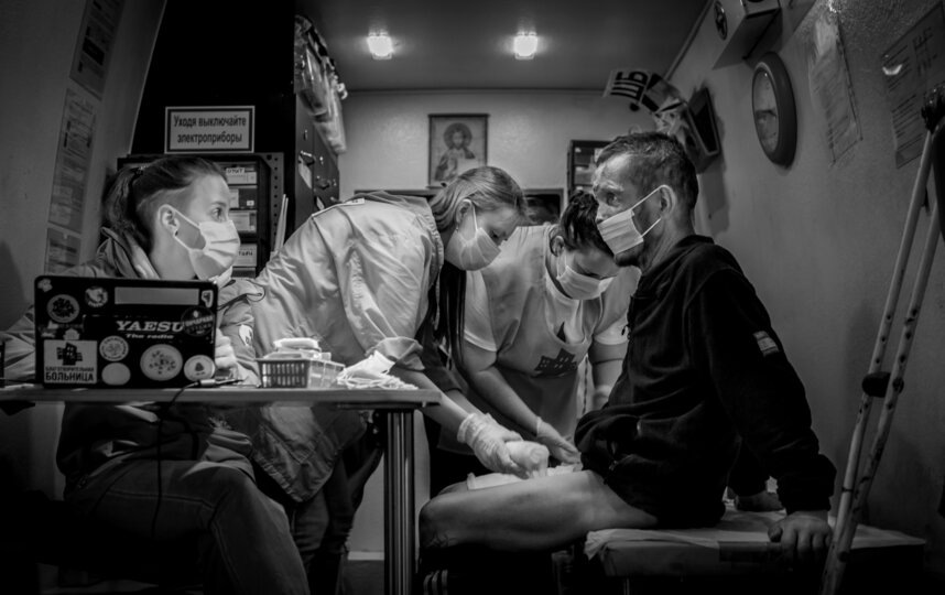    Медики-волонтёры перевязывают раны пациенту мобильной клиники. Приём ведёт врач-травматолог Ника Булавинова.Виталий Курдеко