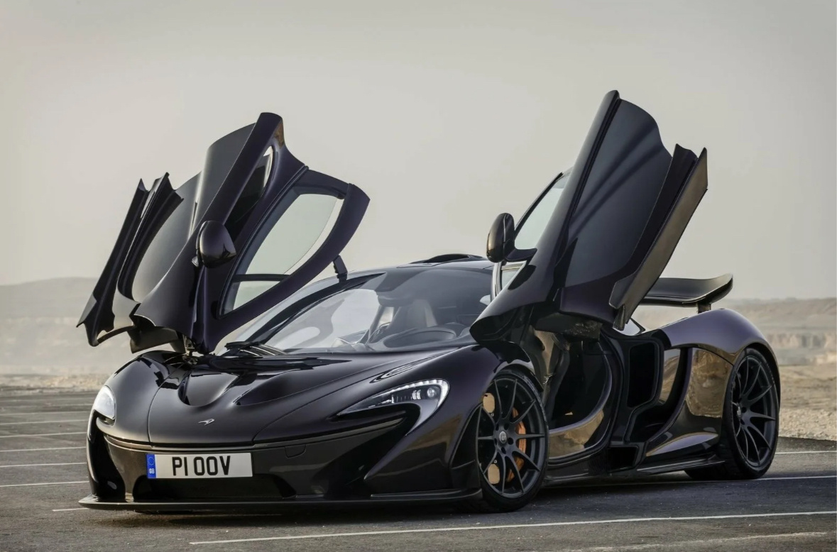 McLaren P1 — это ограниченная серия суперкара, выпущенного британской автомобильной компанией McLaren Automotive. Вот некоторые ключевые характеристики этого автомобиля:

1. **Двигатель**: Гибридный силовой агрегат, состоящий из 3.8-литрового V8 с двойным турбонаддувом и электромотора.
2. **Мощность**: Общая мощность составляет около 903 л.с. (727 л.с. от двигателя и 176 л.с. от электромотора).
3. **Крутящий момент**: Примерно 900 Нм.
4. **Разгон**: Ускорение от 0 до 100 км/ч — менее 3 секунд, а до 200 км/ч — около 6 секунд.
5. **Максимальная скорость**: Ограниченная на уровне 350 км/ч.
6. **Коробка передач**: 7-ступенчатая автоматическая трансмиссия с двойным сцеплением.
7. **Привод**: Полный привод.
8. **Вес**: Около 1,490 кг благодаря использованию углепластиковых и легких материалов.
9. **Дизайн**: Аэродинамическая форма с активными аэродинамическими элементами, включая подвижные спойлеры.
10. **Производительность**: Отличная управляемость и высокая стабильность на дороге благодаря продвинутой системе подвески и шасси.

McLaren P1 был выпущен в ограниченном количестве, что делает его одним из самых желанных суперкаров для коллекционеров.