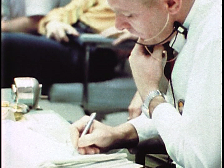 Джин Кранц делает заметки, пытаясь разобраться в ситуации со своими диспетчерами. Фото с сайта translated.turbopages.org.