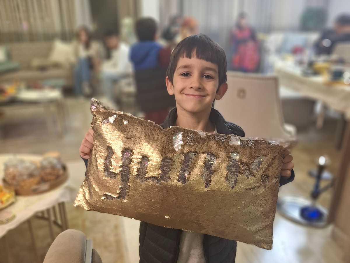 Юнис. Развлекаемся тем, что создаем узоры на декоративных подушках с пайетками. Юни написал свое имя