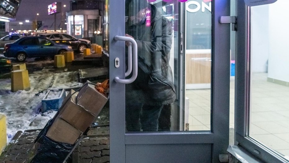    Мужчина закатывает в ПВЗ тележку с посылками. Автор фото: Тихонов Михаил