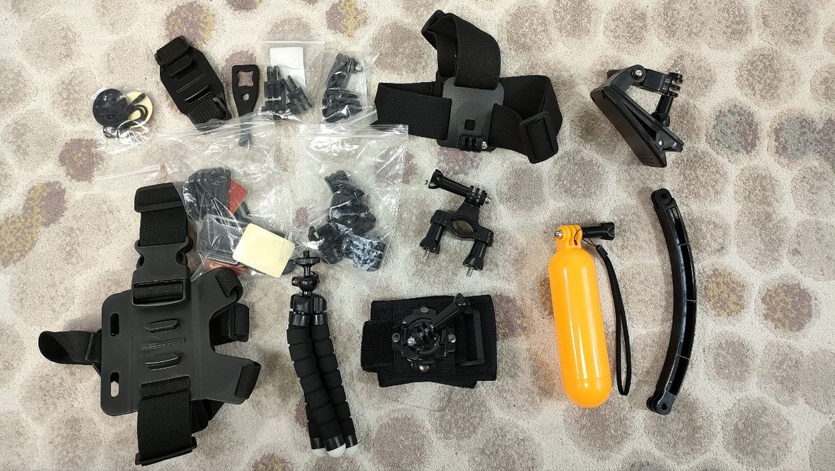 Один из таких наборов в себя включает: клеющиеся крепления на шлем или другие повержности, специальных страховочный шнурок для предотвращения потери камеры в случае нарушения сцепления крепления и шлема, россыпь переходников, головное крепление, прищепка для фиксации камеры на лямке рюкзака, нагрудное крепление, трипод с гнущимися ножками, крепление на руку, поплавок и планка для выноса камеры. Так же в наборе были, но в кадр не попали монопод и присоска.