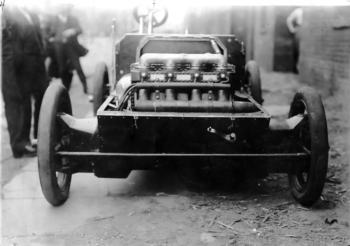 на автомобиль Кристи 1903 года был установлен двигатель с рабочим объемом 606 кубических дюймов (9,9 л), который развивал мощность 30 л.с. (22 кВт). Свечи зажигания находятся в центре пространства камеры сгорания, примыкающего к цилиндрам. Над каждой свечой зажигания был расположен набор из четырех впускных клапанов, а ниже – один выпускной клапан. Обратите внимание на выпускной коллектор. Рукоятка на передней части автомобиля использовалась для запуска двигателя
