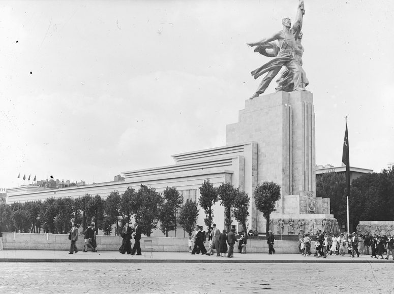 Павильон СССР на Всемирной выставке 1937. Наверху — скульптура "Рабочий и колхозница" В.И. Мухиной. Перед павильоном — пропилеи с барельефами на тему народов СССР работы И.М. Чайкова. Фото: https://lechronoscaphe.com/exposition-internationale-des-arts-et-techniques-appliques-a-la-vie-moderne-1937/