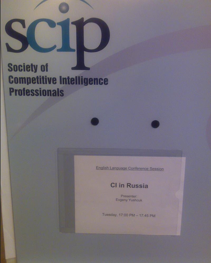    Евгений Леонидович Ющук – признанный не только в России, но и в мире специалист конкурентной разведки (адаптированной к гражданскому обороту версии государственной разведки, работающей исключительно в рамках гражданского законодательства). На фото – указатель на аудитории, на международной конференции специалистов конкурентной разведки, проходившей в Риме. Спикер – Евгений Ющук