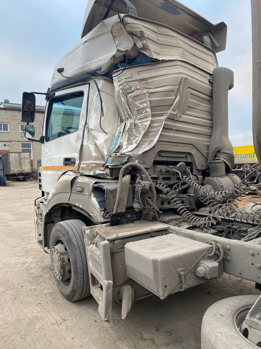 Сильно поврежденная кабина грузовика после ДТП, множественные вмятины и деформации с правой стороны.