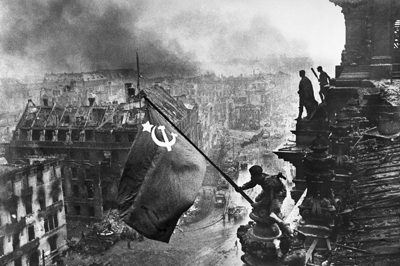 Бойцы 8-й гвардейской армии РККА Алексей Ковалев и Абдулхаким Исмаилов (слева направо) с красным знаменем на крыше здания Рейхстага после взятия города советскими войсками в ходе Второй мировой войны.
