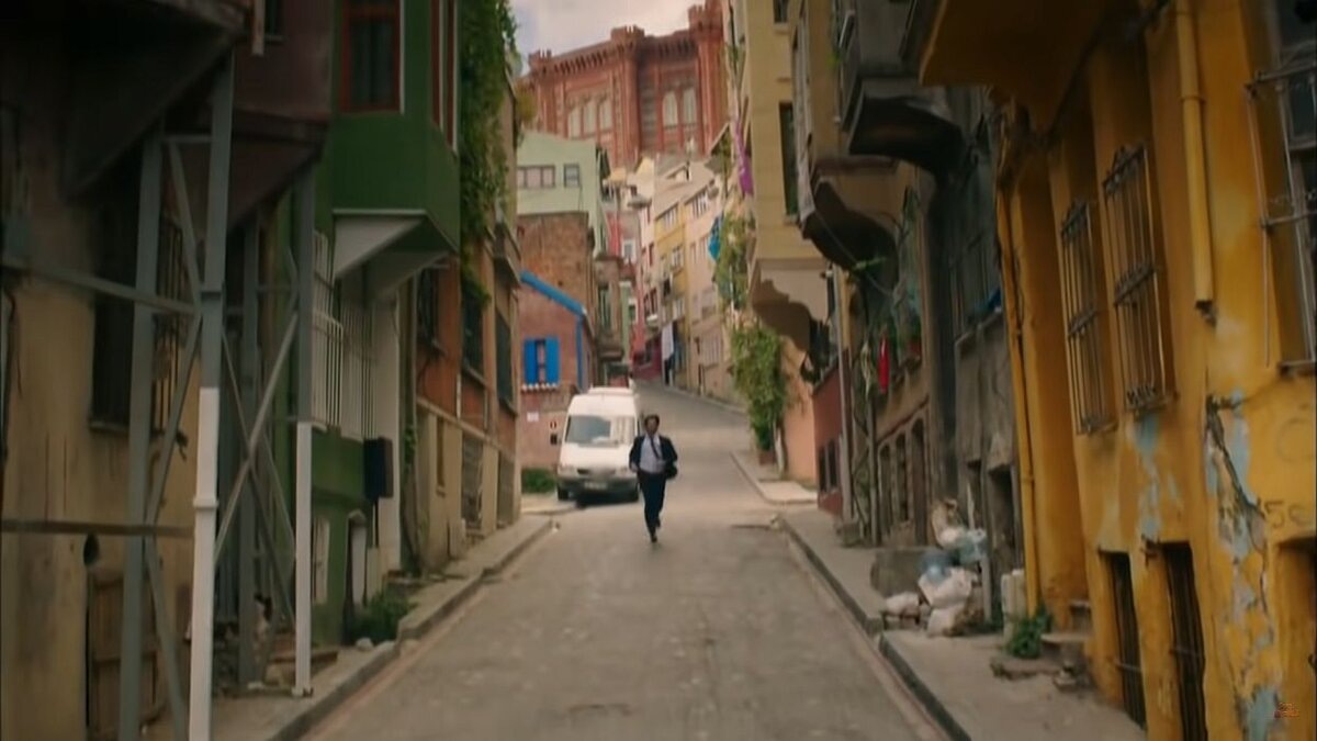 Эмир бежит по улице, которая упирается в здание школы. Кадр из сериала «Дело чести», Турция, 2014 год