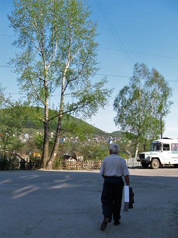 Фотографии Татьяны Немшановой. Город Аша. Первые числа мая 2010. Последнее фото папы. Через полгода папы не стало.  Здесь стояла бабушкина банька, плескалось озеро, плавали караси; летали стрекозы; цвели бабушкины яблони, вишни. Теперь тут асфальт, конечная остановка автобуса. На фото папа спешит в наш сад. Березка росла в нашем саду. В моем детстве она была  юна и тонка.