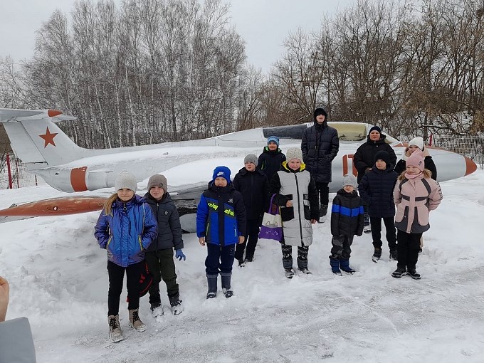 Дети рядом с самолётом в дворе музея