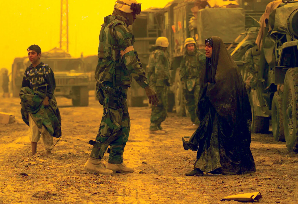 Война в Ираке. Американские морские пехотинцы помогают перемещённым иракским гражданам.