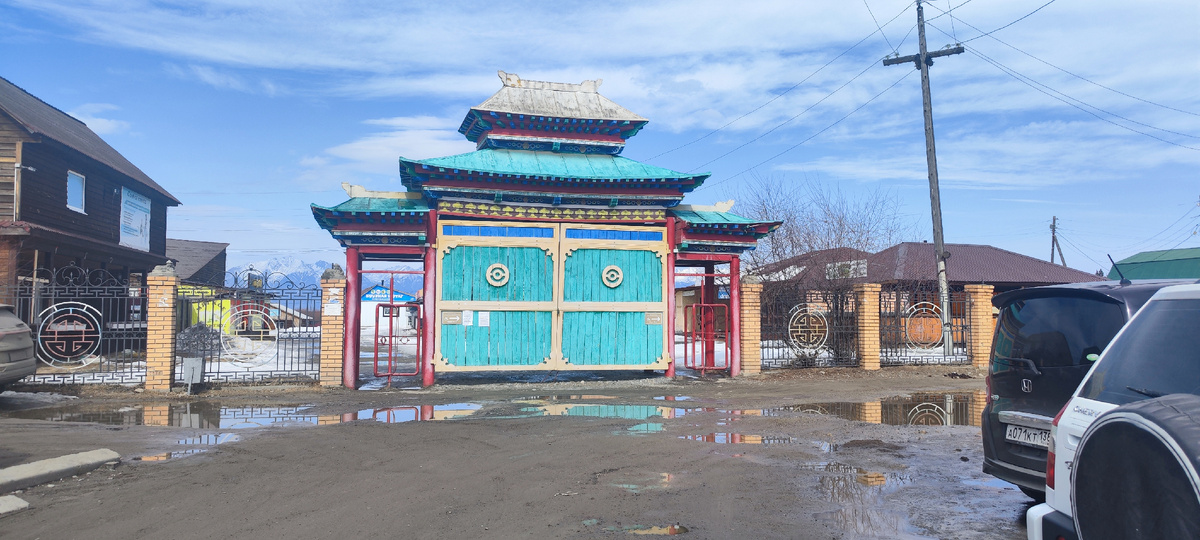 Яркие цветные ворота на фоне голубого неба смотрятся великолепно. Пожалуй это единственное яркое пятно во всем поселке