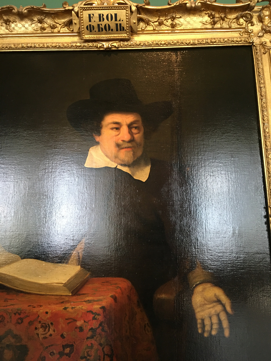 Портрет мужчины за столом с книгой.