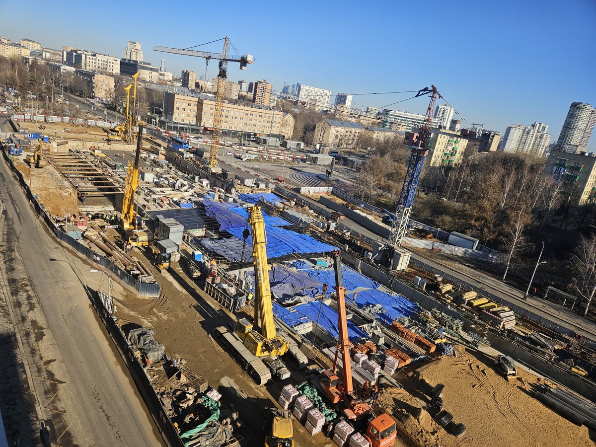 📷 1.1: Западный вестибюль. На бывшей проезжей части Профсоюзной улицы работают буровые установки. С их помощью практически без перерыва выполняется обуривание котлована пересадочного коридора, ведущего в центр зала 🚇 станции Калужско-Рижской линии.