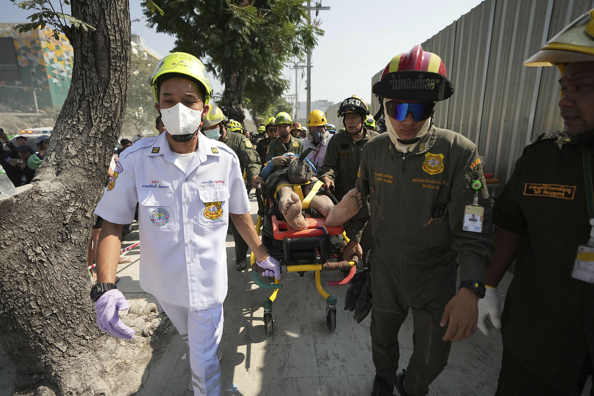    Спасатели выносят пострадавшего с площадки обрушившегося после землетрясения здания, Бангкок, Таиланд, 28 марта 2025 года