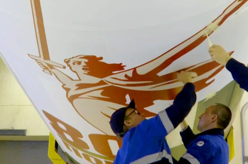    Идёт наклейка официального логотипа (с кадров видеозаписи госкорпорации «Роскосмос»)