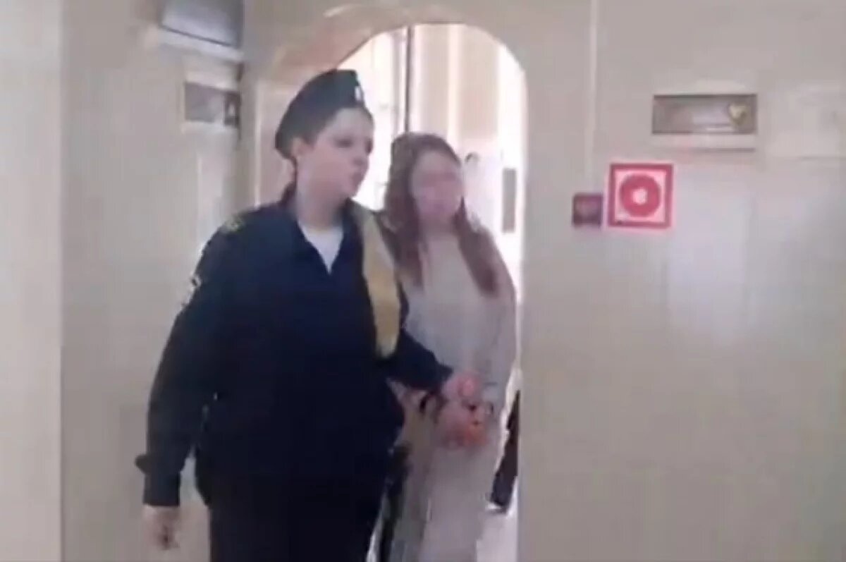    Маму мальчика ведут в зал суда.