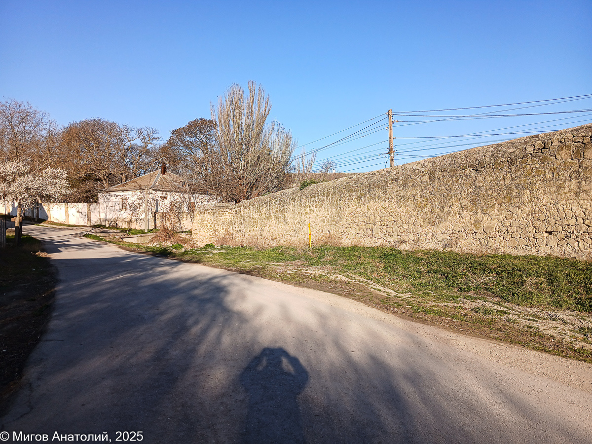 Старая каменная стена, огороживающая Карантин. Белый домик - это одно из больничных зданий.