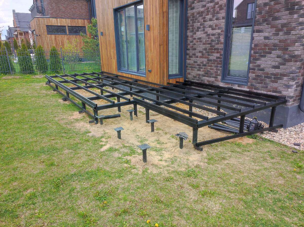 Каркас террасы на винтовых сваях. Несколько свай выступают на меньшую высоту — это опоры для ступеней