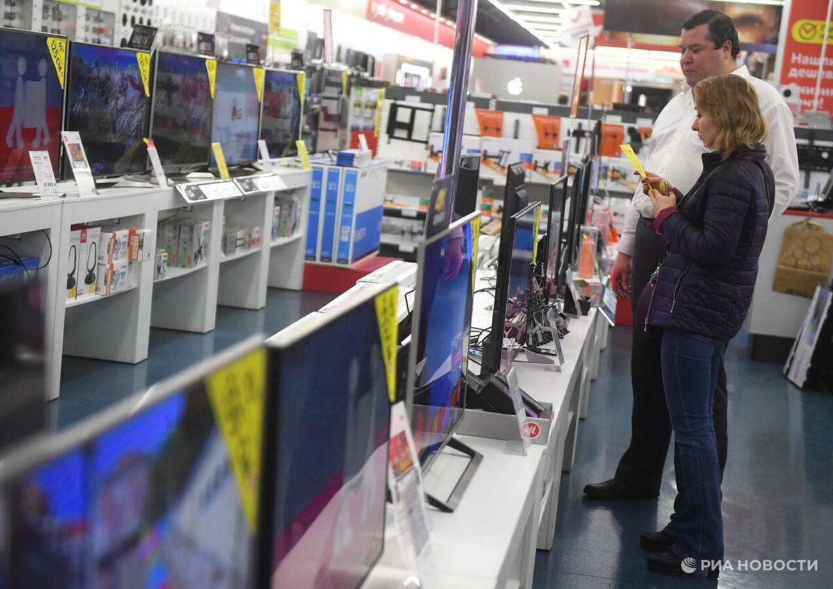 Посетители рассматривают телевизоры в магазине по продаже цифровой и бытовой техники в Москве. Архивное фото © РИА Новости / Евгений Одиноков
